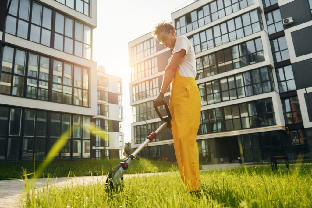 Beautiful sunshine. Man cut the grass with lawn mover outdoors in the yard.